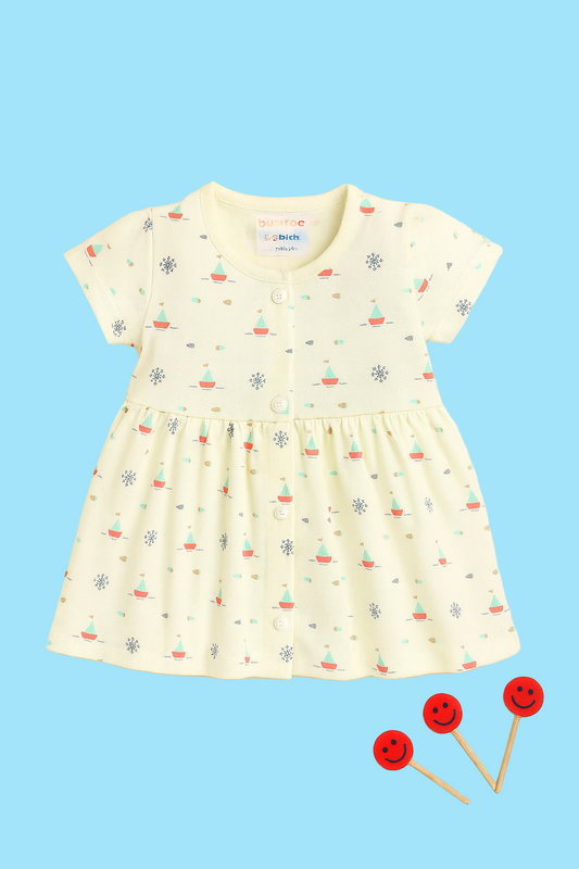 Children's dress with sailboat pattern on a beige background
